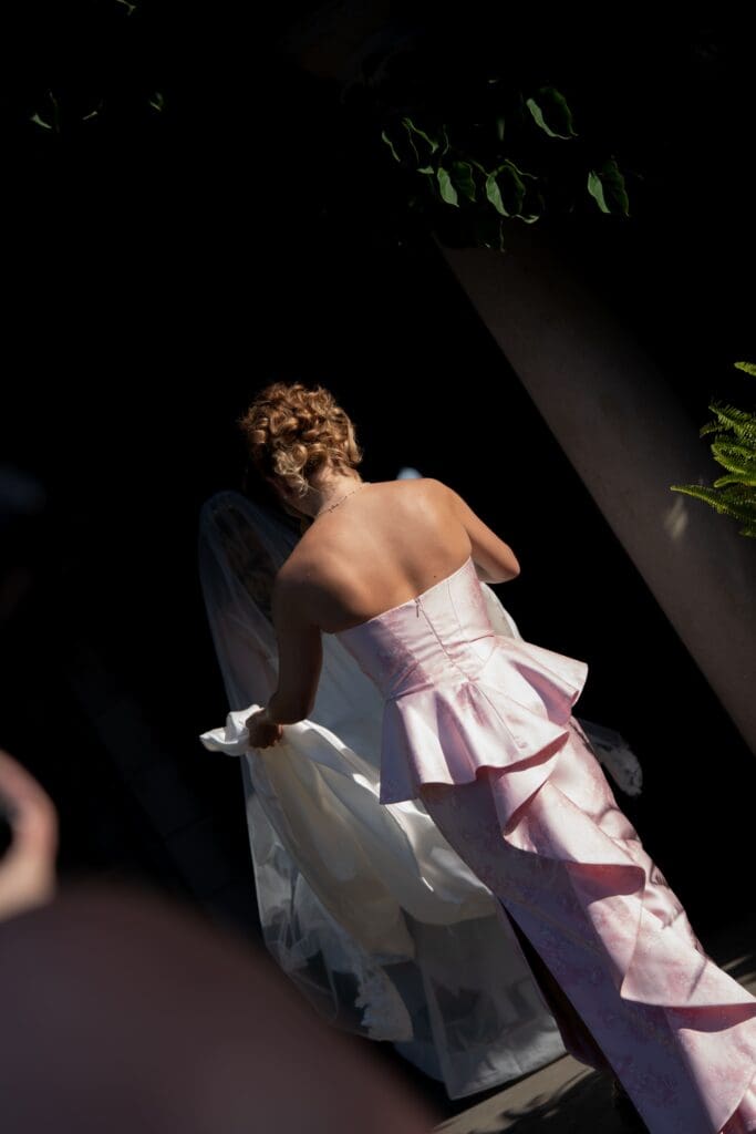 A guest in a sculptural pink gown steps into dramatic light during the reception, captured with a cinematic approach by a CT wedding photographer.