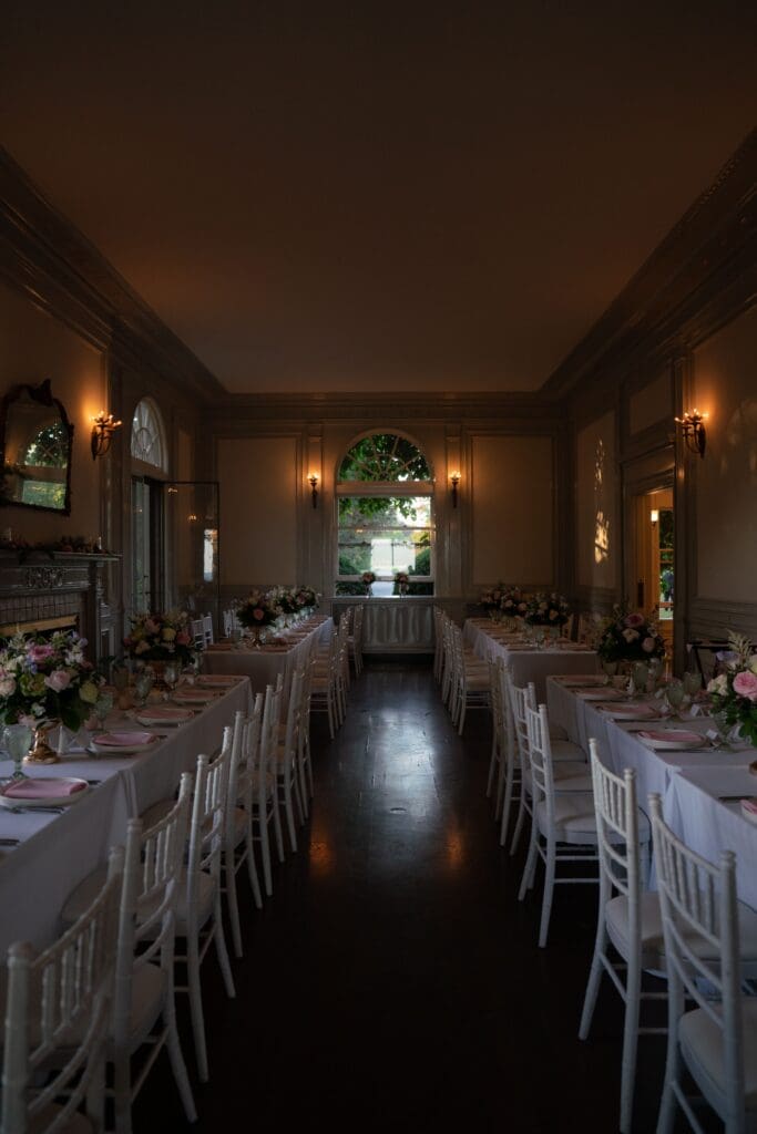 Long reception tables line a warmly lit dining room, styled for an intimate celebration photographed by a CT wedding photographer for elegant weddings.