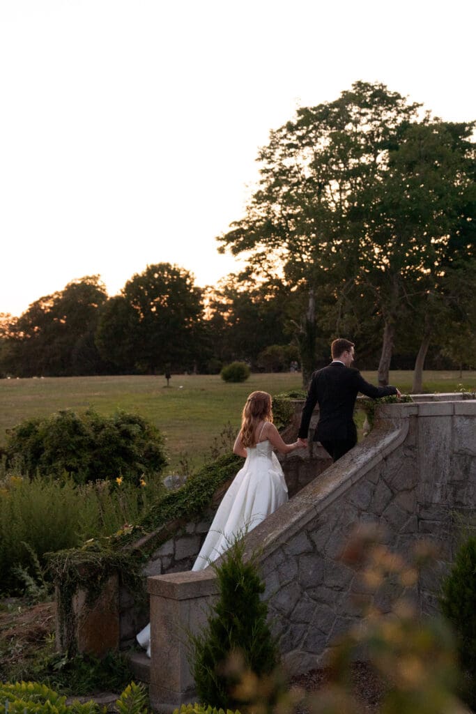 From the garden steps, the bride and groom look out across the grounds at sunset during an Eolia Mansion wedding day.