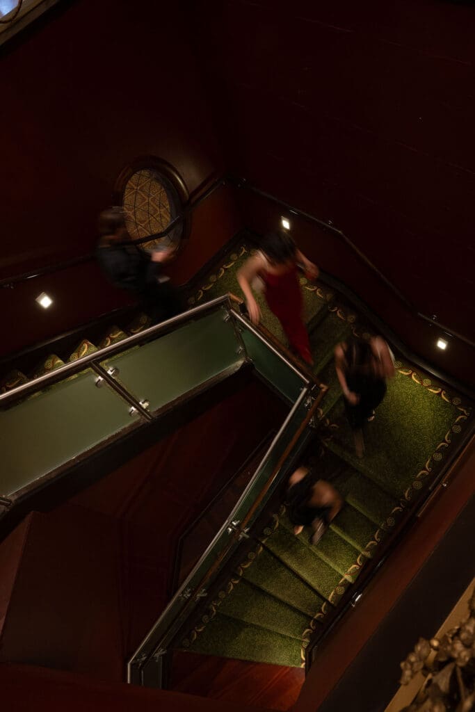 From above, guests move around the curved staircase in a cinematic overhead composition by a wedding photographer CT.