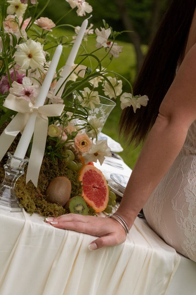 Floral styling with taper candles, citrus, moss, and layered textures creates a refined tabletop detail for a wedding photographer CT editorial.